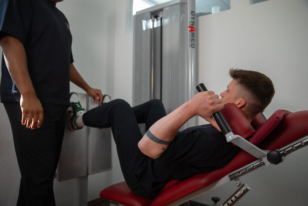 Ein Patient übt Übungen an der Beinpresse aus.